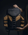 Vanta 22 EPX — seated lifestyle shot showing minimal professional backpack design
