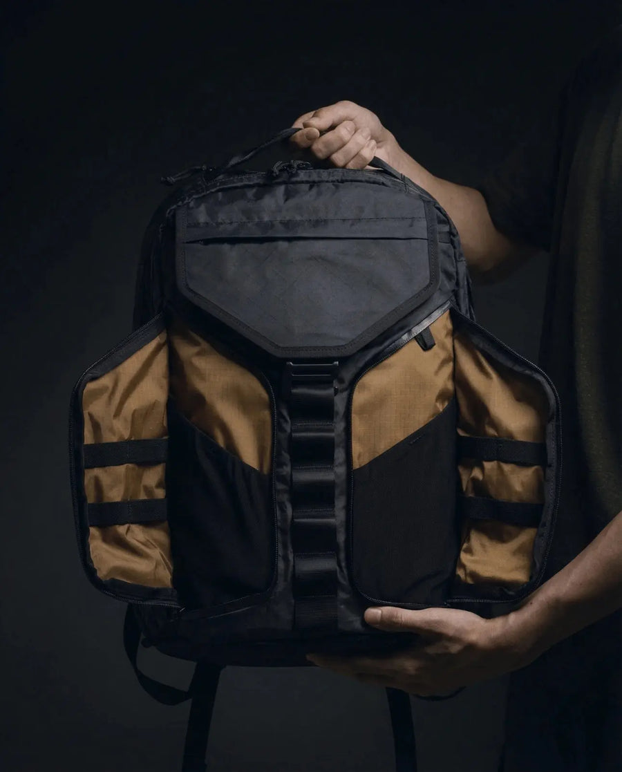 Vanta 22 EPX — seated lifestyle shot showing minimal professional backpack design